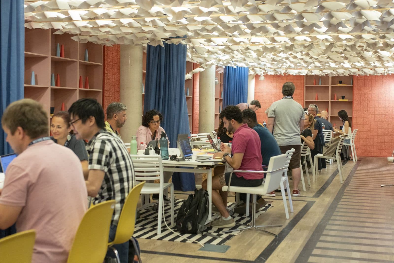 A wide view of the room in session during the June 2026 edition, participants working together.